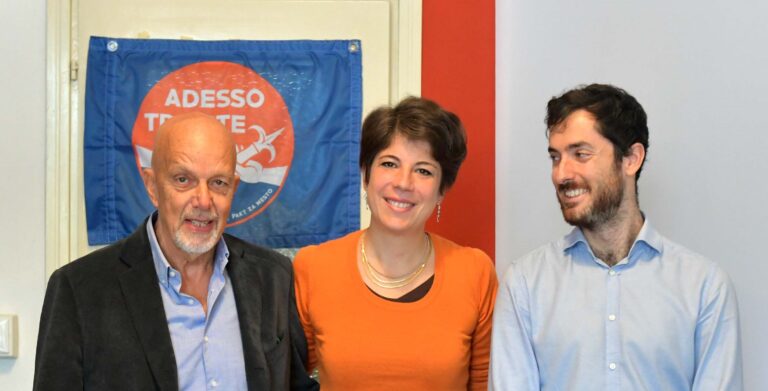 Giulia Massolino con il team Adesso Trieste, sorridenti in ufficio.