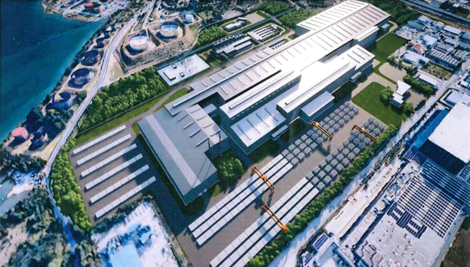 Complesso industriale costiero con magazzini, piazzali logistici e banchine sul mare.