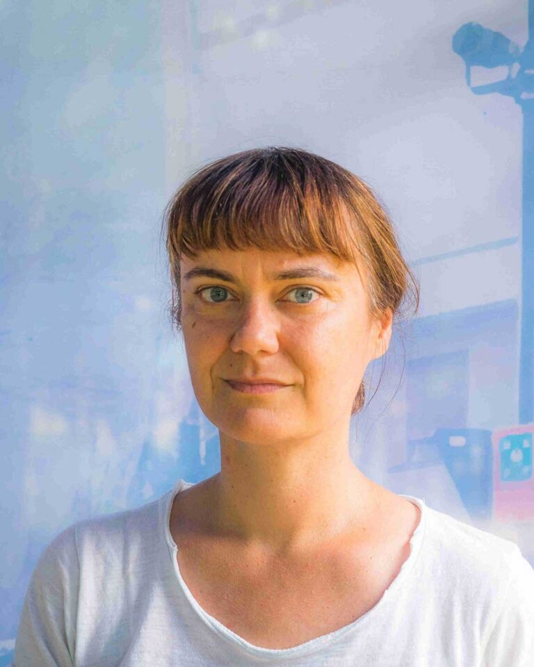 Ritratto naturale di Lucia Vazzoler con occhi azzurro-verdi, capelli castani e maglia bianca.
