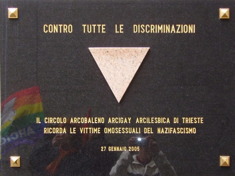 Targa LGBTQ+ Trieste contro le discriminazioni, con triangolo rosa e memoria del nazifascismo.