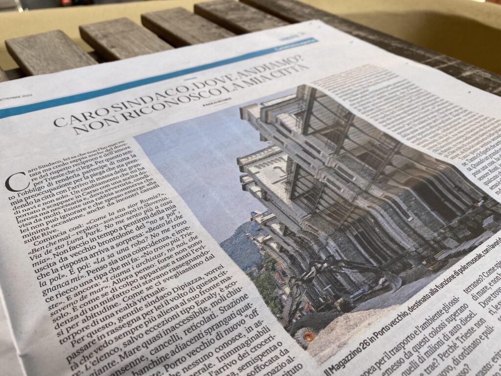 Articolo di giornale all’aperto su tavolo in legno con foto industriale e titolo serif.