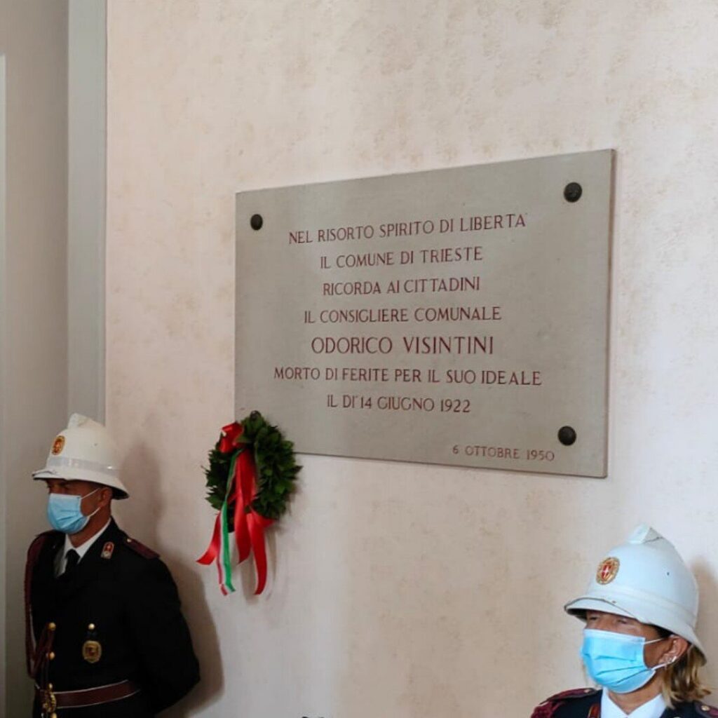 Targa commemorativa a Trieste per Odorico Visintini, con guardie cerimoniali e corona tricolore.