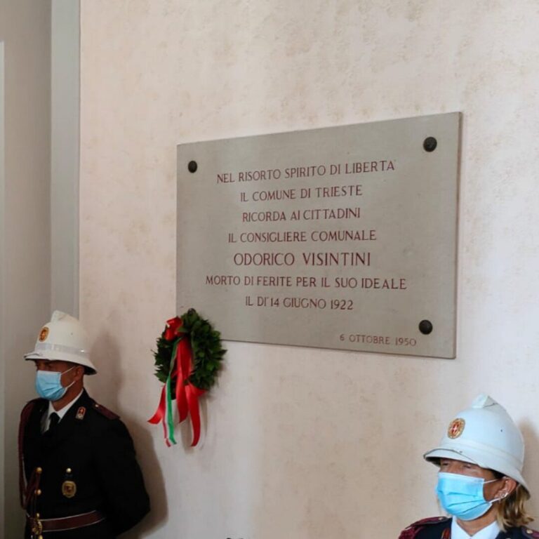 Targa commemorativa a Trieste per Odorico Visintini, con guardie cerimoniali e corona tricolore.
