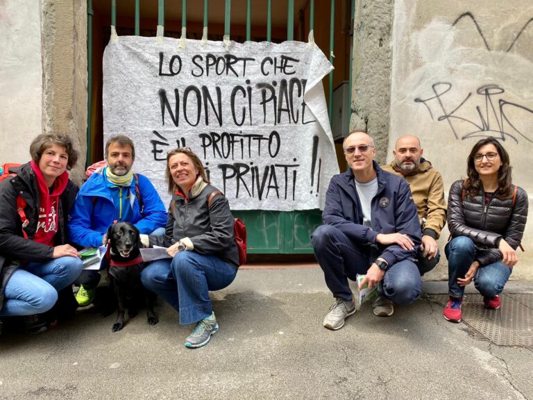 Gruppo di attivisti con cane e striscione contro la privatizzazione dello sport in strada.